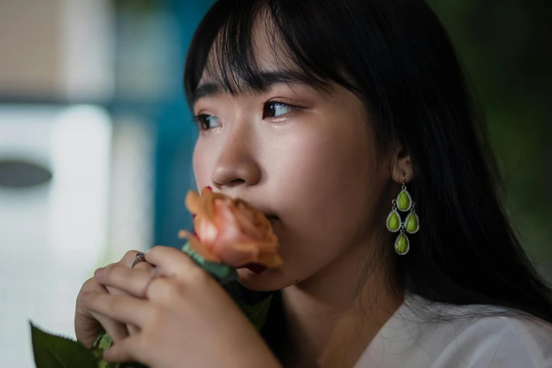 a close up of a person eating a flower, long earrings, wenfei ye, shot with sony alpha 1 camera, portait image