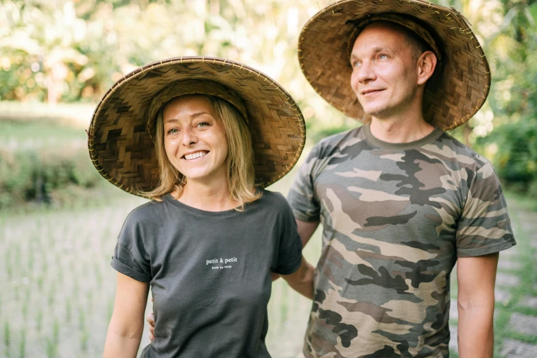 a man and a woman standing next to each other, a portrait, by Gen Paul, pexels contest winner, wearing a tee shirt and combats, straw hat, paradise garden massage, thumbnail