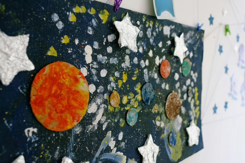 a close up of a piece of art on a wall, space art, dressed in stars and planets, cardboard, slide show, crafts