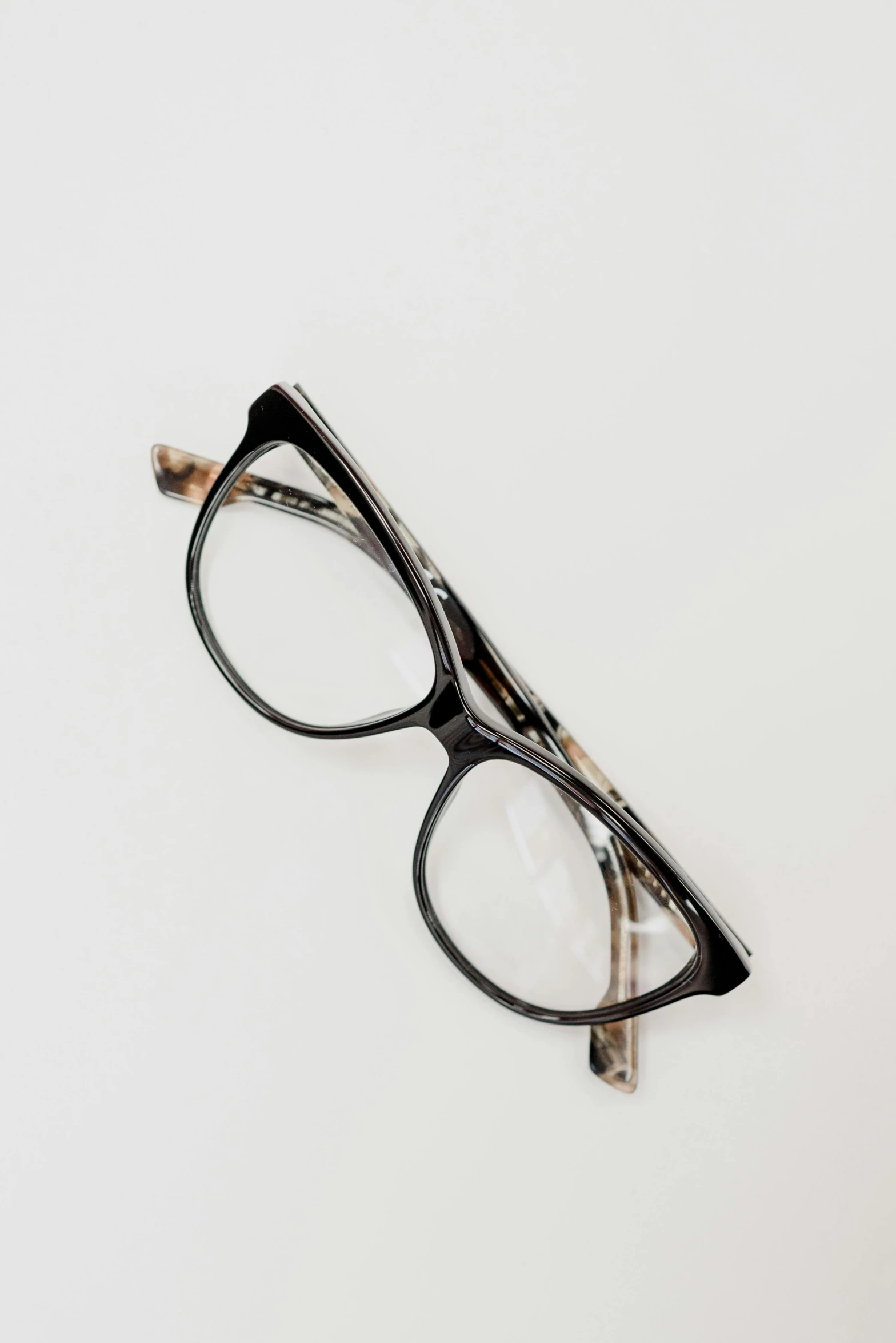 a pair of glasses sitting on top of a table, a picture, speckled, black on white background, no frames, high view