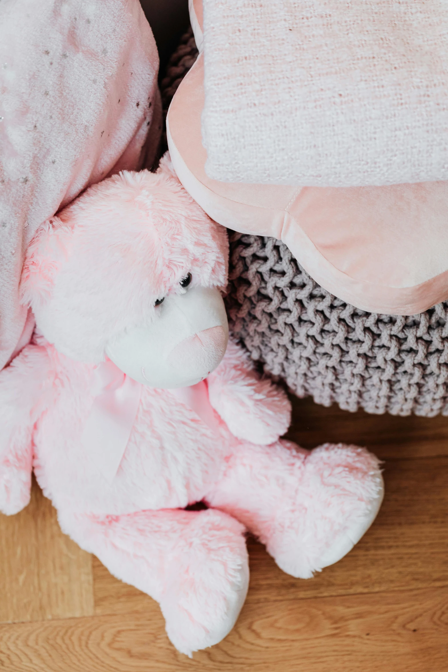 a pink teddy bear sitting next to a basket of blankets, pink and pink details, premium quality, head down, light pink mist