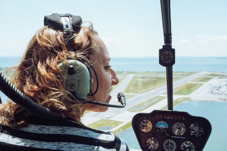 a woman in a helicopter looking out the window, views to the ocean, avatar image