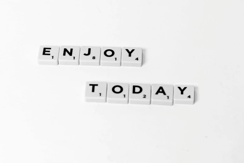 the word enjoy today spelled in scrabbles on a white surface, a picture, by Emma Andijewska, pixabay, 🦩🪐🐞👩🏻🦳, minimalist photo, january and february, contentment