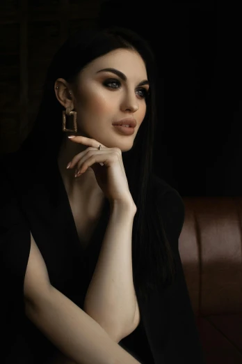 a woman sitting on top of a brown couch, a portrait, trending on pexels, arabesque, black jewellery, young beautiful amouranth, 15081959 21121991 01012000 4k, hand on cheek