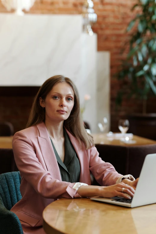 a woman sitting at a table with a laptop, wearing a blazer, angelina stroganova, avatar image, multiple stories