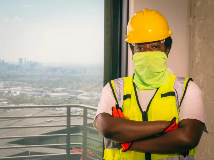 a construction worker standing in front of a window, a portrait, pexels contest winner, with a yellow green smog sky, aida muluneh, wearing facemask, chief keef