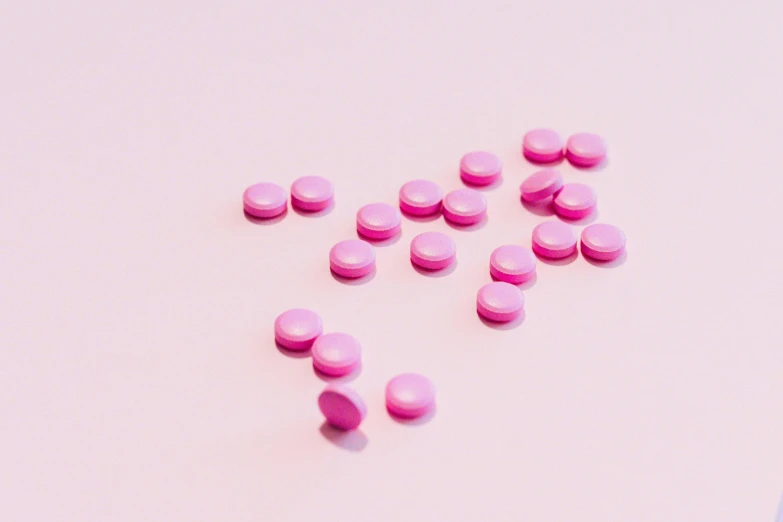 pink pills arranged in the shape of a heart on a pink surface, an album cover, trending on pexels, antipodeans, flying saucers, studs, purple tubes, medicine