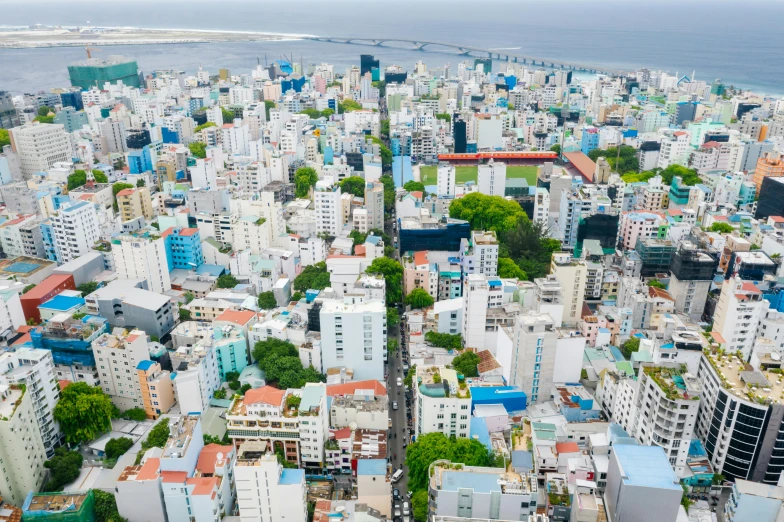 a large city with lots of tall buildings, by Sam Dillemans, pexels contest winner, hurufiyya, tropical coastal city, zoomed out to show entire image, maldives in background, vietnam