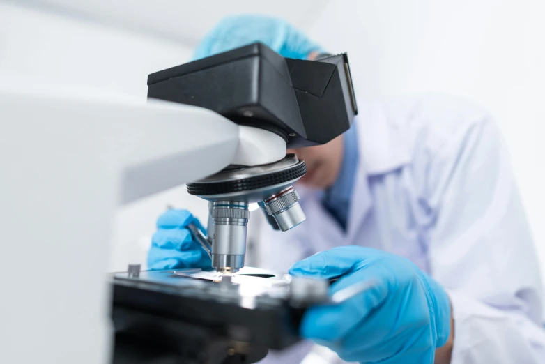 a man in a lab coat looking through a microscope, a microscopic photo, shutterstock, fan favorite, low quality photo, thumbnail