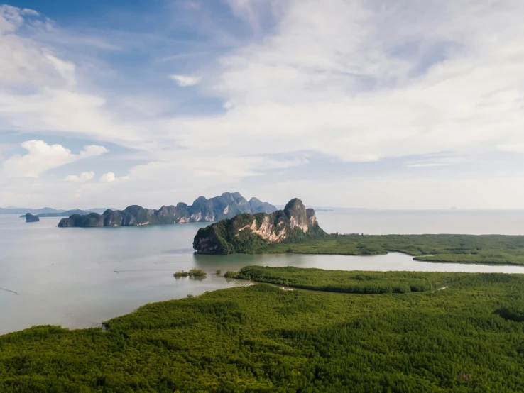 a large body of water surrounded by trees, a matte painting, by Seb McKinnon, pexels contest winner, thailand, view from helicopter, islands on horizon, conde nast traveler photo