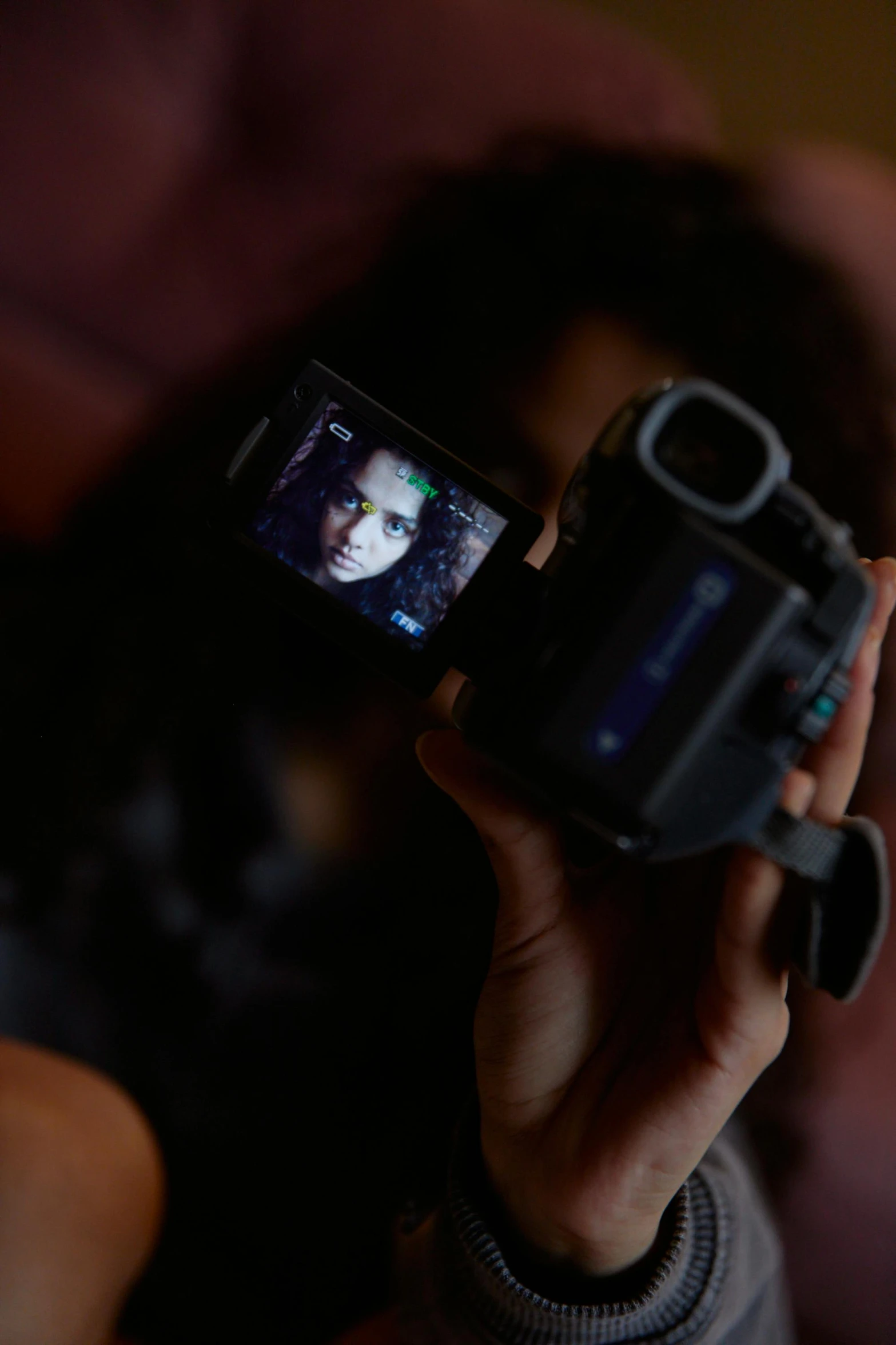 a close up of a person holding a camera, inspired by Nan Goldin, video art, tessa thompson inspired, they share one head. cinematic, person in foreground, spooky found footage