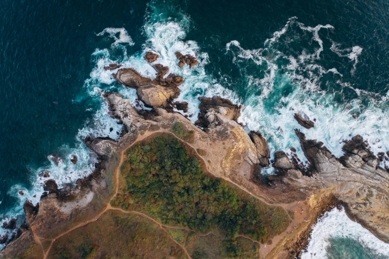 an aerial view of the ocean and rocks, pexels contest winner, landslides, satellite imagery, excitement, skull island