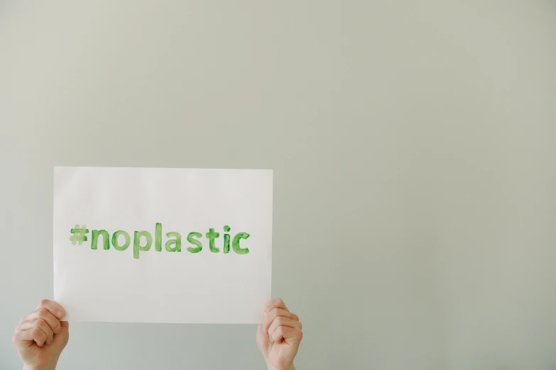 a person holding up a sign that says no plastic, trending on unsplash, neoplasticism, monochromatic green, on a pale background, bioorganic concept, realistic footage