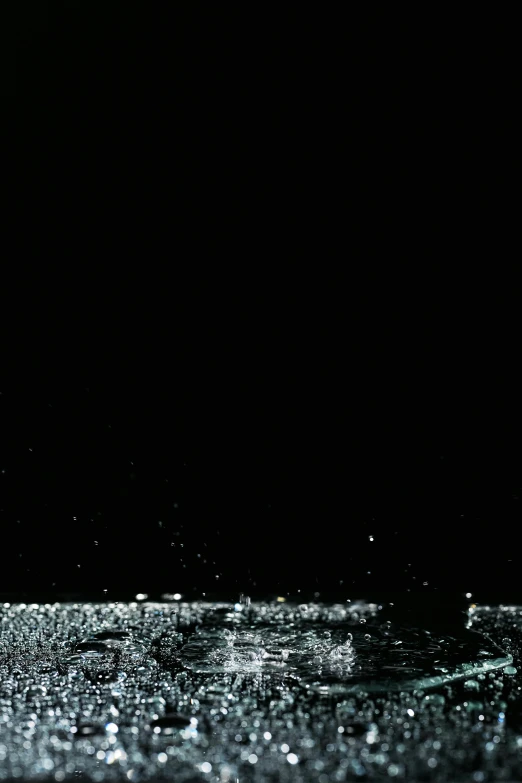 a glass filled with water sitting on top of a table, an album cover, by Ryoji Ikeda, reddit, glitter gif, black sky, glowing lights!! highly detailed, white noise