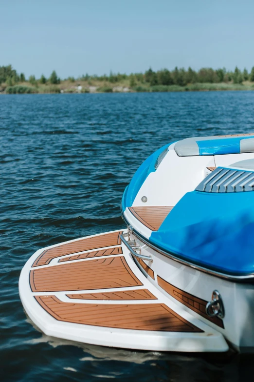 a blue and white boat sitting on top of a body of water, up close shot, luxury equipment, wooden trim, espoo