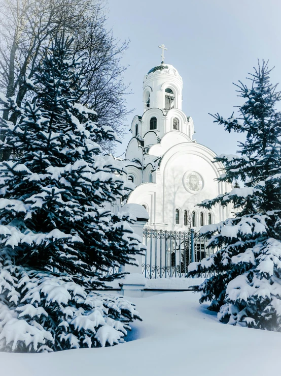 a church surrounded by trees covered in snow, a photo, inspired by Vasily Surikov, pexels contest winner, art nouveau, white and silver, high resolution photo, medium height, album cover