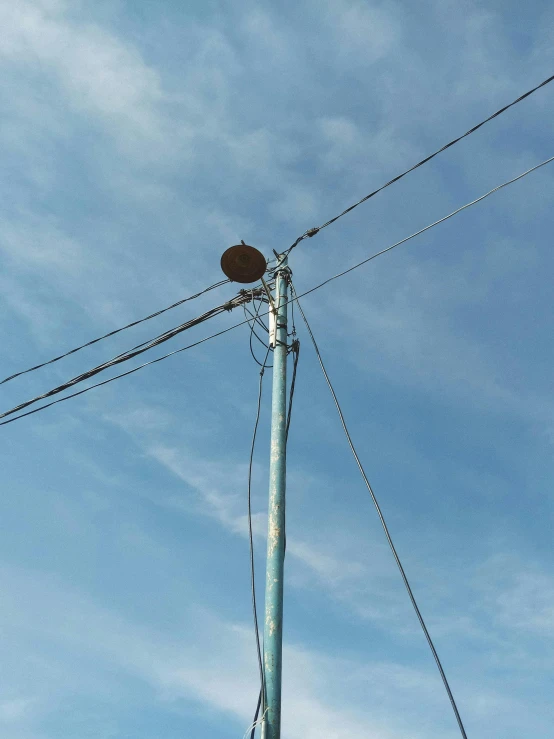a telephone pole with a blue sky in the background, an album cover, low quality photo, bright thin wires, single image