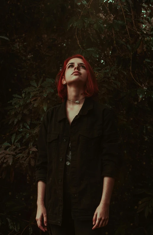 a woman with red hair standing in a forest, an album cover, inspired by Elsa Bleda, trending on pexels, antipodeans, portrait androgynous girl, portrait of ((mischievous)), dark clothes, concert