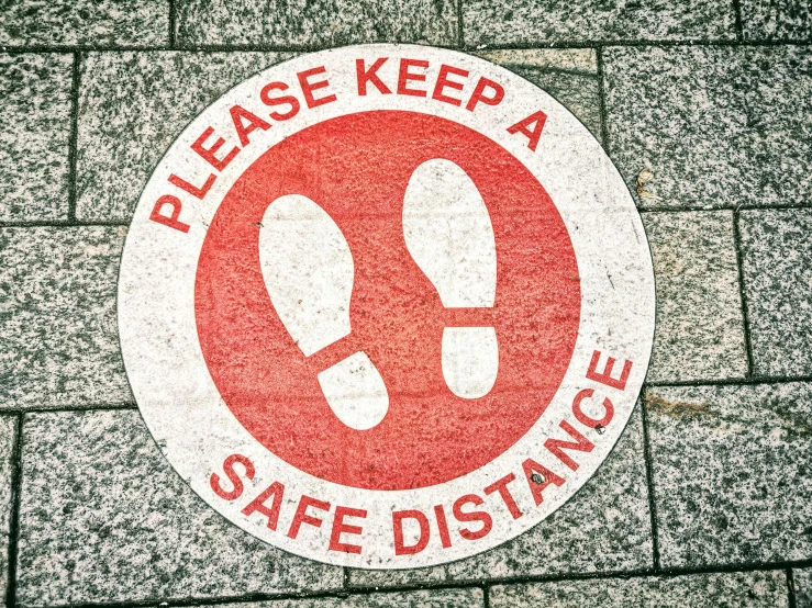 a red and white sign that says please keep a safe distance, by Julia Pishtar, shutterstock, stand on stone floor, silver, footprints, circular