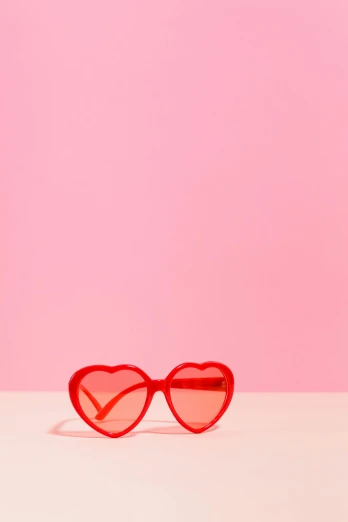 a pair of red heart shaped sunglasses on a pink background, by Nathalie Rattner, ap, vivid), ((pink)), prints