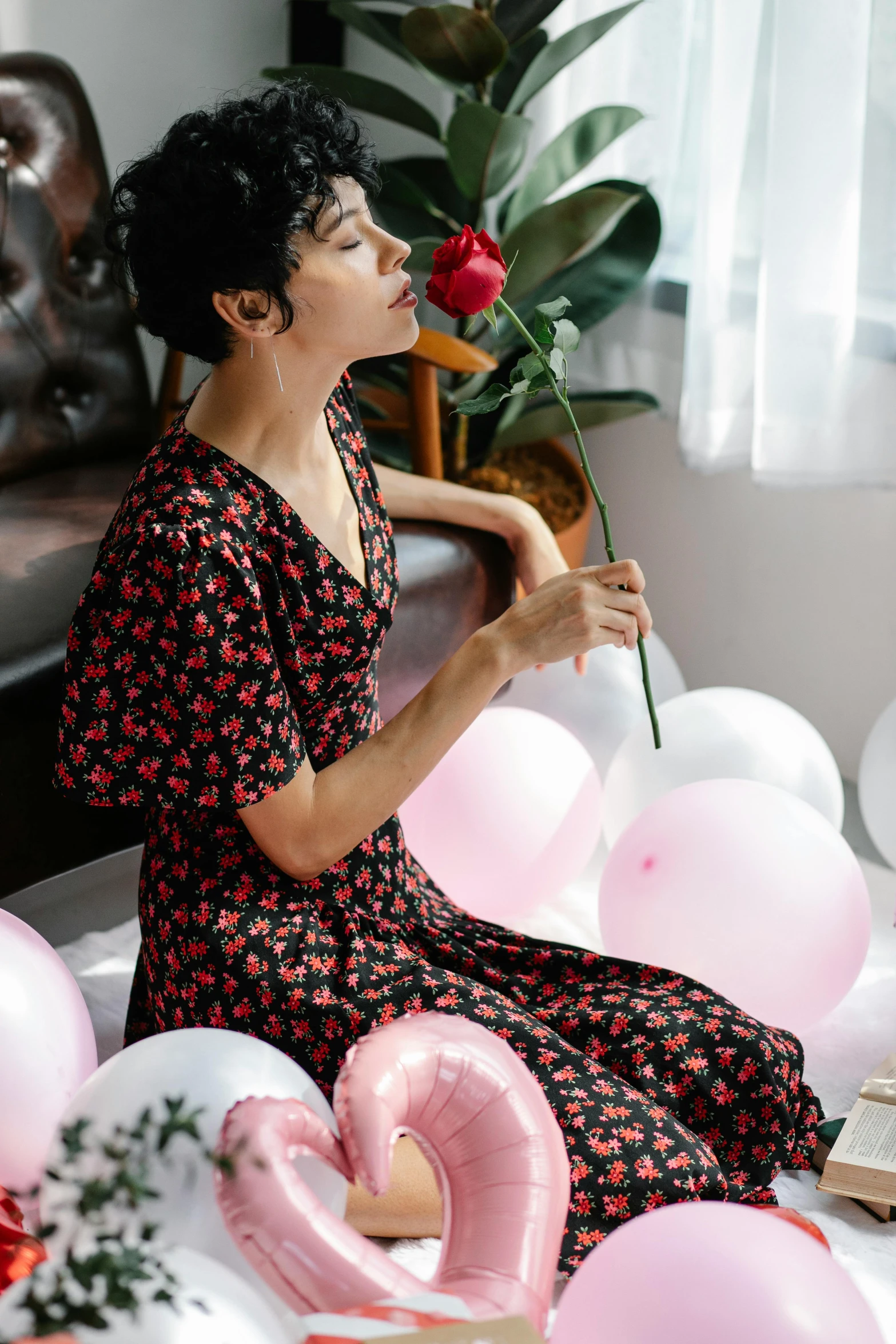 a woman sitting on a bed with balloons and a rose, instagram, red floral dress, 奈良美智, soft silk dress, with black