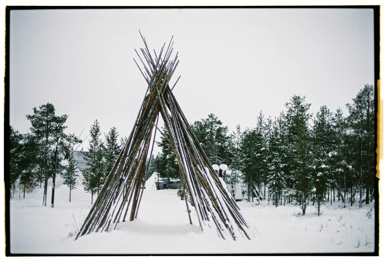 a teepee in the middle of a snowy forest, an album cover, inspired by karlkka, unsplash, land art, wood sculpture, museum photo, 35mm color photo, signed