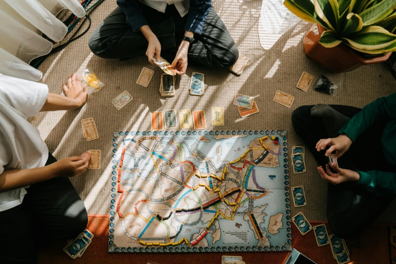 a group of people sitting on the floor playing a board game, by Kristian Zahrtmann, pexels contest winner, visual art, 🚿🗝📝