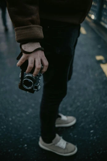 a close up of a person holding a camera, pexels contest winner, standing in road, low quality photo, rugged details, hands