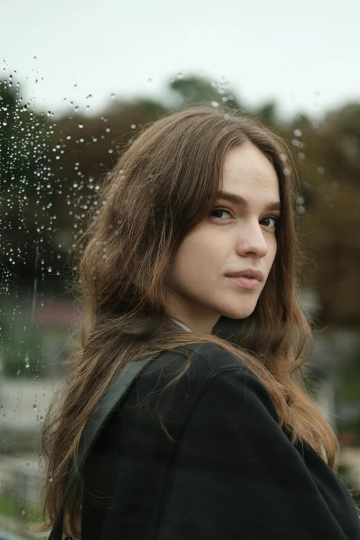 a beautiful young woman standing in front of a window, by Attila Meszlenyi, pexels contest winner, realism, wet flowing hair, large forehead, concert, overcast weather