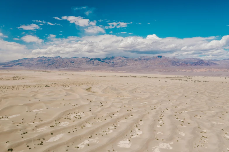 a view of a desert with mountains in the distance, by Ryan Pancoast, unsplash contest winner, land art, aerial footage, background image, deserted sand, central california