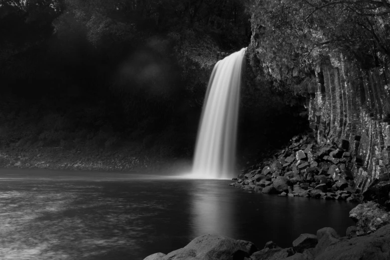 a black and white photo of a waterfall, a black and white photo, by Dan Frazier, romanticism, bioluminescent waterfall, waterfall falling into a lake, te pae, medium format photography