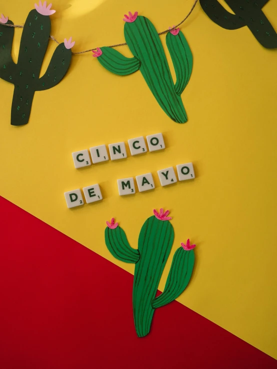 a sign that says cinco de mayo on a yellow and red background, by Carey Morris, pexels contest winner, cubes on table, cactus, monthly, made out of clay