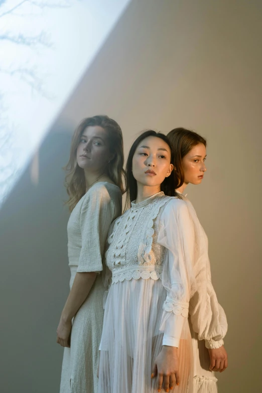 three women standing next to each other in a room, an album cover, unsplash, renaissance, light dress, gongbi, portrait image, concert