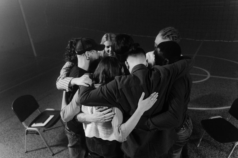 a group of people standing around each other, a black and white photo, by Maurycy Gottlieb, pexels, renaissance, spirit hugs, circle pit, church, sports photo