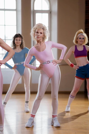a group of women standing on top of a wooden floor, inspired by Graham Forsythe, trending on tumblr, covered in pink flesh, biopic, in a gym, 1 9 8 0 s woman