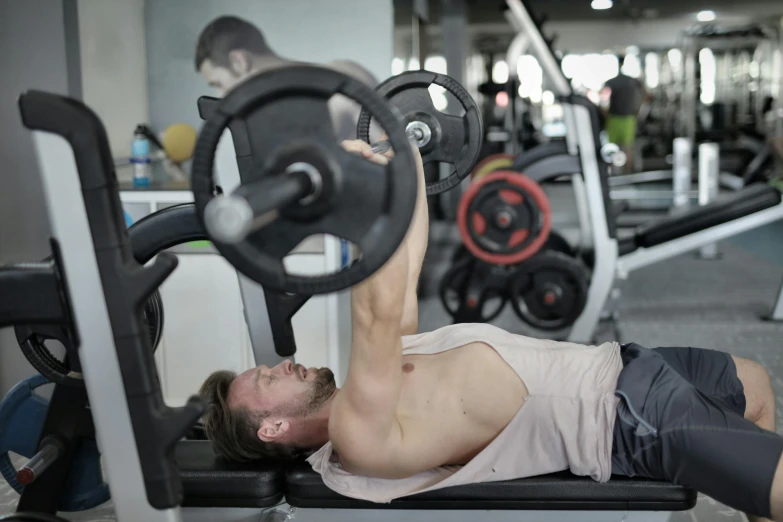 a man doing a bench press in a gym, a photo, by Matija Jama, happening, profile image, center of image, lachlan bailey, low quality photo