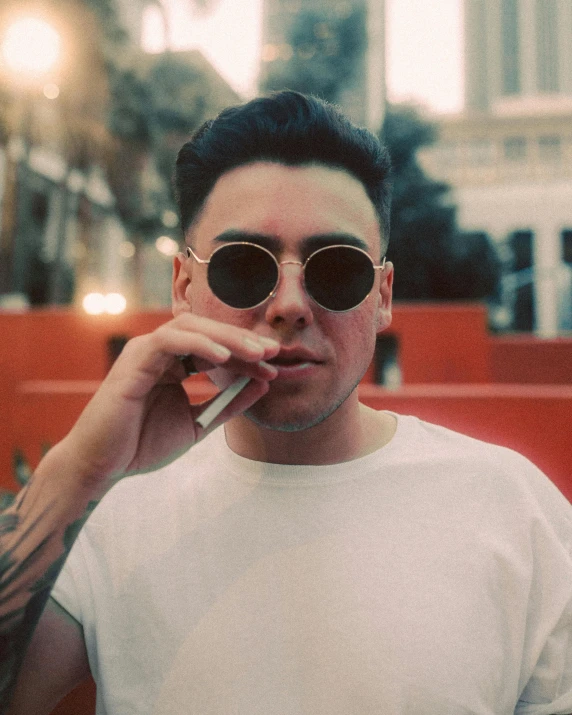 a man in a white shirt smoking a cigarette, an album cover, by Jessie Alexandra Dick, trending on unsplash, bad bunny, julian ope, handsome chad chin, shades