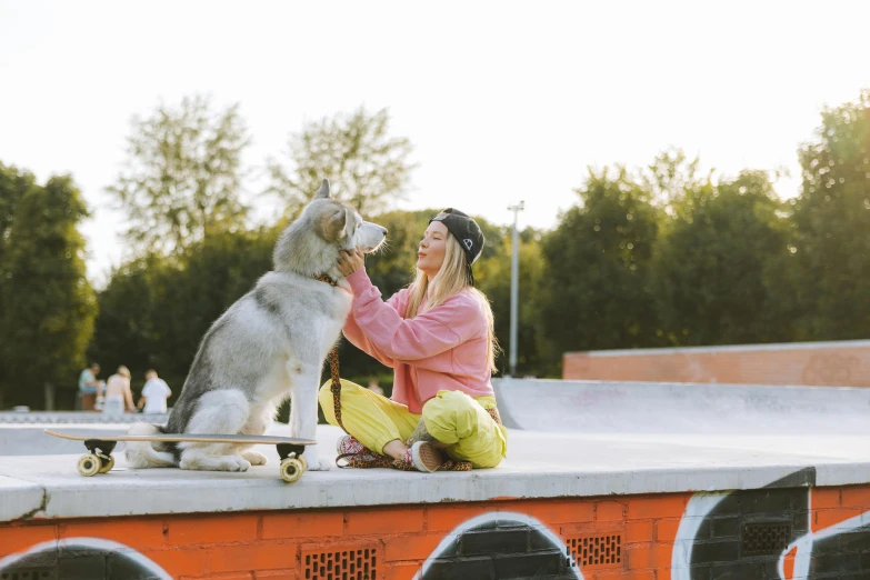 a woman sitting on top of a skateboard next to a dog, profile image, skatepark, husky, 4k post