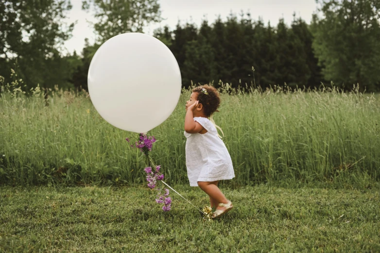 a little girl holding a white balloon in a field, pexels contest winner, happening, decoration, outside on the ground, pregnant, violet myers