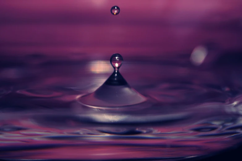 a close up of a drop of water, by Cherryl Fountain, unsplash, art photography, purple tones, levitation, 4 k hd wallpapear, low - angle shot