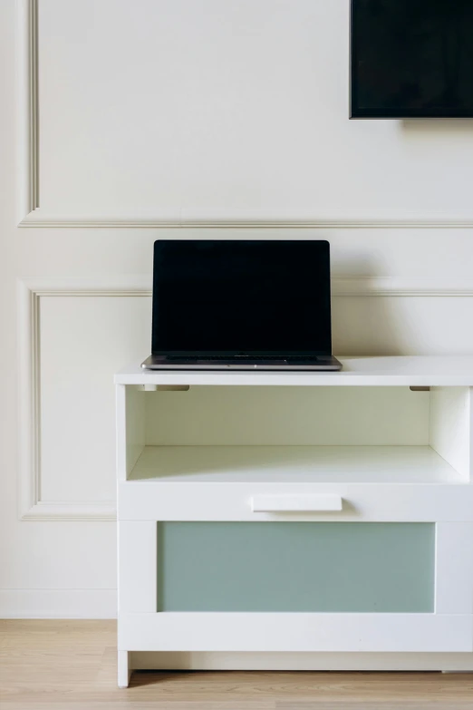 a laptop computer sitting on top of a white cabinet, by karlkka, stockphoto, square, medium close-up shot, small room