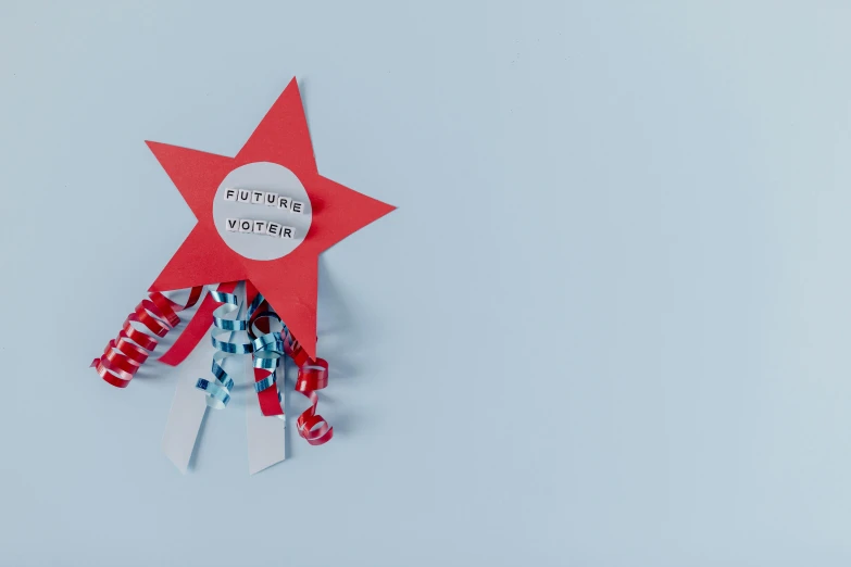 a red star with a ribbon attached to it, by Julia Pishtar, pexels contest winner, visual art, stick poke, text on paper, bright blue future, vostok-1