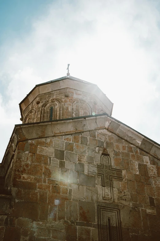 a very tall building with a clock on top of it, an album cover, unsplash, romanesque, orthodox christianity, stone roof, light glare, georgic