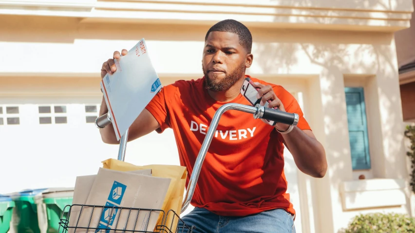 a man sitting on top of a bike holding a clipboard, pexels contest winner, hurufiyya, delivering packages for amazon, kevin hart, avatar image, wearing pants and a t-shirt