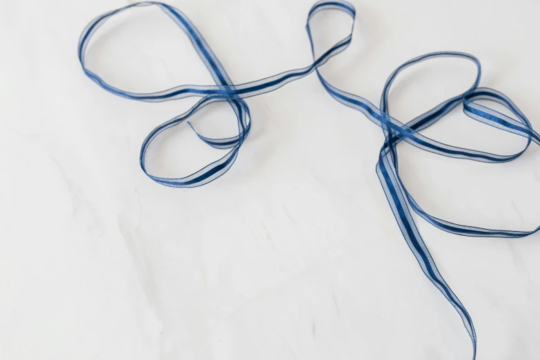 a pair of scissors sitting on top of a table, by Helen Stevenson, unsplash, arabesque, double very long braids blue, wide ribbons, set against a white background, thin long fine lines