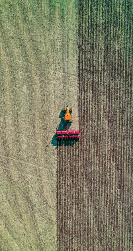 an aerial view of a tractor plowing a field, by Andries Stock, unsplash contest winner, color field, wearing a red gilet, 15081959 21121991 01012000 4k, sustainability, minimalist