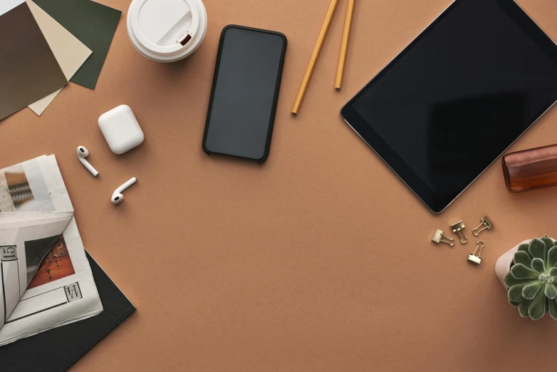 a tablet computer sitting on top of a table next to a cup of coffee, trending on pexels, minimalism, brown colours, phone wallpaper. intricate, various items, classroom background