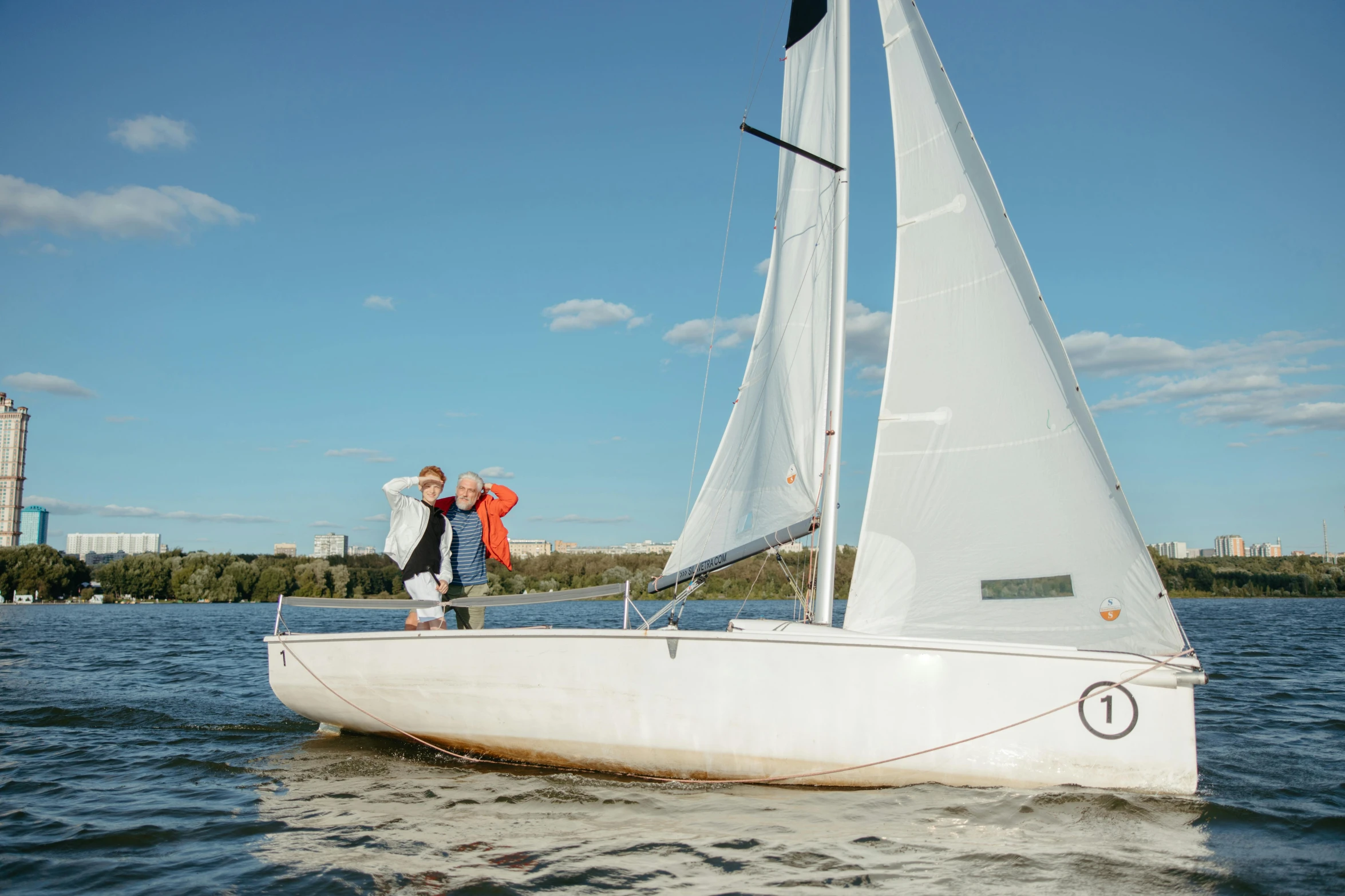 a man and a woman standing on a sailboat, happening, espoo, beginner, & a river, having fun