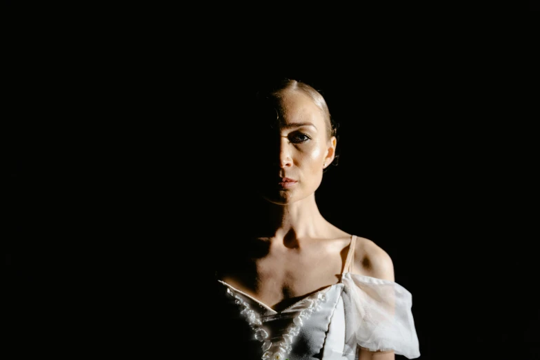 a woman in a white dress posing for a picture, a portrait, by Elizabeth Polunin, unsplash, neo-figurative, spotlight in middle of face, dark ballerina, half and half, photograph taken in 2 0 2 0
