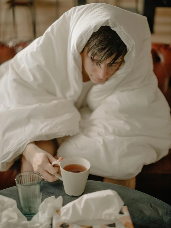 a person wrapped up in a blanket with a cup of tea, inspired by Vasily Perov, trending on unsplash, wearing white silk hood, loveable guy, gif, confident relaxed pose